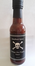 Tall round clear glass sealed bottle containing Jonathan's Spices Tobago Hot Pepper Sauce